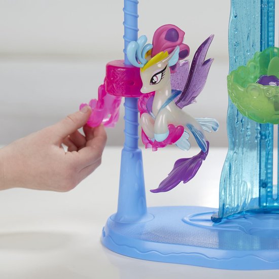 Mooie witte zeepaardjesfiguur met vleugels, paarse staart en roze accenten op een blauwe standaard.