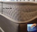 Dichtbij van een 12cm dik matras met reliëf en een hand die schuim indrukt.