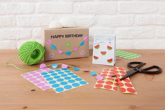 Cadeaupapier met slingers, een witte tas met watermeloenstickers en rolletjes touw.