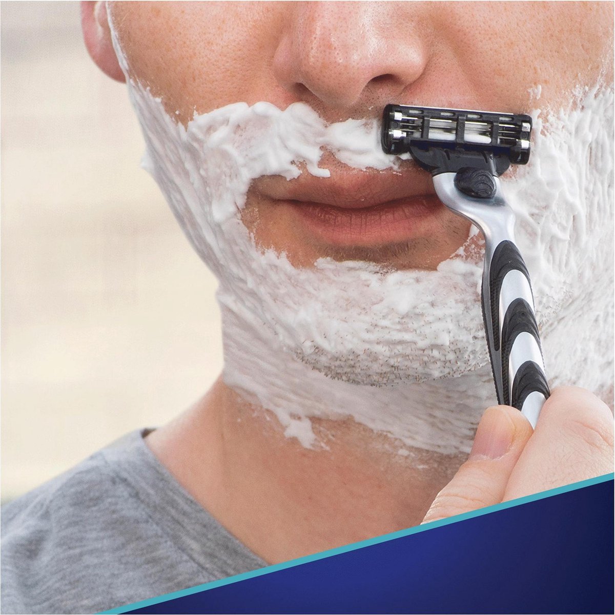 Verpakking Gillette Mach3+ scheermesjes, 5 stuks. Met de tekst LAMÉS AMÉLIORÉES VERBETERDE MESJES.