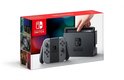Nintendo Switch doos met console, grijze Joy-Con controllers en dock, met een hand die de console in het dock plaatst.