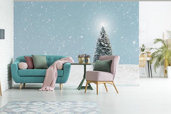 Behang - Fotobehang Een kerstboom in een besneeuwd landschap en een blauwe hemel - Breedte 525 cm x hoogte 350 cm