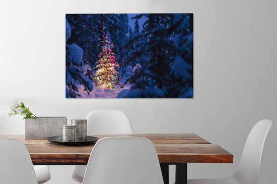 Canvas Schilderij Een kerstboom in het besneeuwde bos - 90x60 cm - Wanddecoratie - OneMillionCanvasses