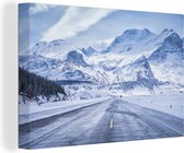 Canvas Schilderij Een besneeuwde weg in de bergen - 180x120 cm - Wanddecoratie XXL
