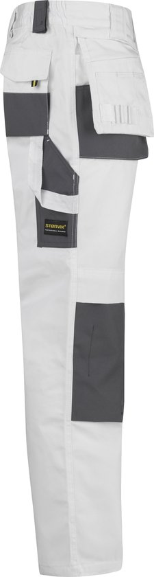 Zijzicht van een witte werkbroek met donkergrijze zakken en kniestukken. Een gele patch met merknaam.