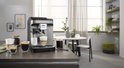 De'Longhi Magnifica EVO volautomatische espressomachine in titanium zwart, met koffie en melk.
