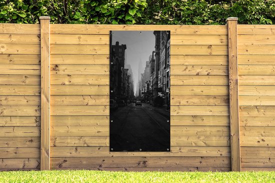 Affiche de clôture Une voiture roule dans une rue calme de New York en noir et blanc - 100x200 cm - Toile jardin