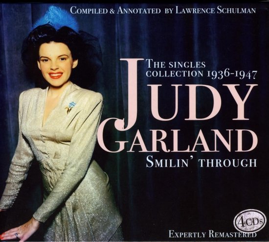 Judy Garland op de hoes van "Smilin' Through: The Singles Collection 1936-1947". Ze draagt een glinsterende jas, blauwe hoed met veren, en rode lippenstift.
