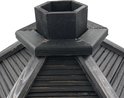 Detail van de achthoekige schoorsteen van een donker, houten vogelhuisje.