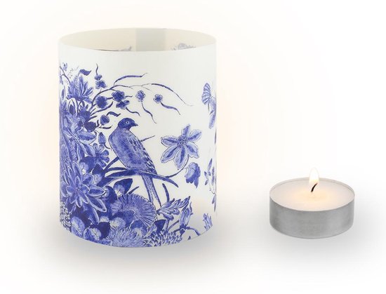 Kaarshouder met Delfts blauw patroon van een vogel tussen de bloemen, naast een brandend waxinelichtje.