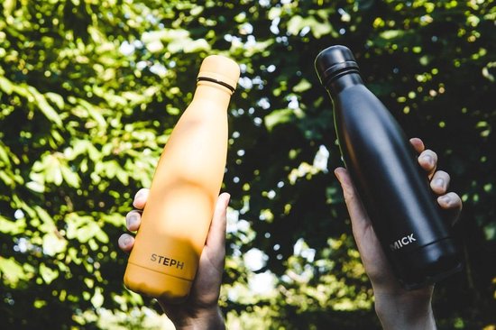 Gele fles met 'Steph' en zwarte fles met 'Mick', elk in een hand gehouden.