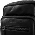 Detail van de zwarte leren schoudertas van The Chesterfield Brand met een reliëf logo en een rits.