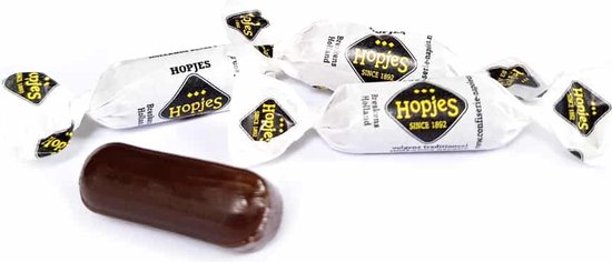 Een losse drop en een paar individueel verpakte hopjes. De verpakkingen zijn wit met gele en zwarte opdruk.