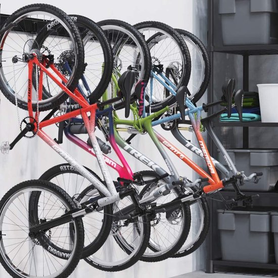 Vijf mountainbikes met kleurrijke frames hangen aan een zwart ophangsysteem.