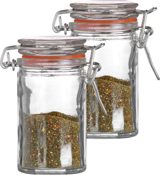 Deux petits pots de conserve en verre remplis d'un mélange d'épices, avec joints orange et fermetures à levier en métal.