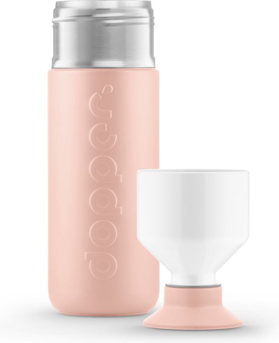 Dopper Insulated drinkfles in pebble peach met een witte dop en een bijpassende witte beker op een peach voetstuk.