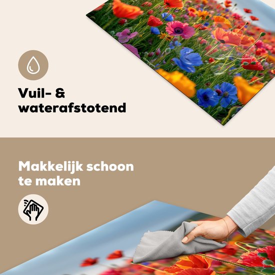 Een close-up van een kookplaatafdekking met rode, oranje, roze en blauwe klaprozen. Een hand veegt het oppervlak schoon.