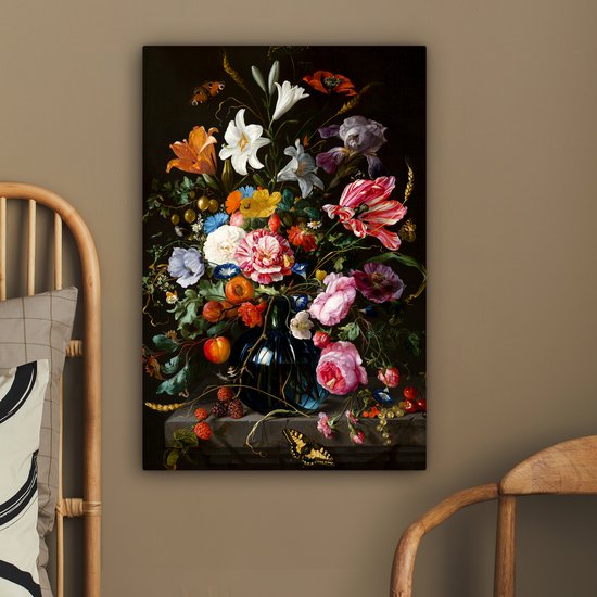 Une chambre avec une tête de lit en rotin et une chaise en bois, à laquelle est accrochée une peinture d'une nature morte florale.