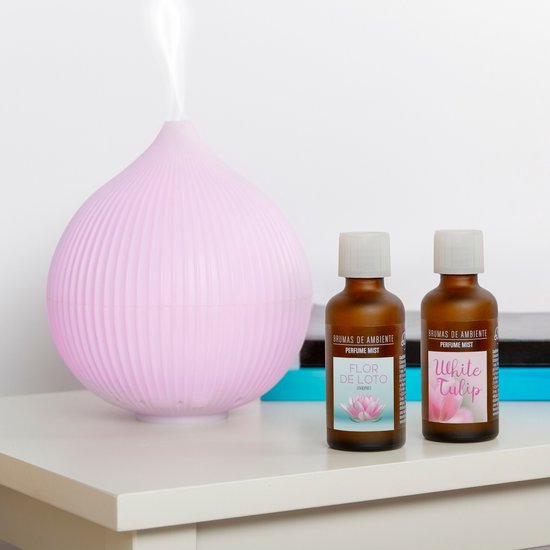 Roze diffuser met stoom en twee flesjes parfum met tulpenafbeeldingen.