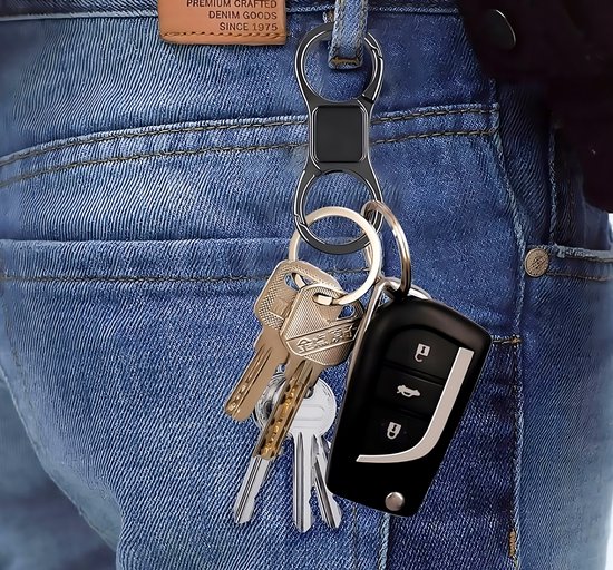 Zwarte dubbelzijdige karabijnhaak sleutelhouder met sleutelbos en autosleutel, gedragen aan een spijkerbroek.