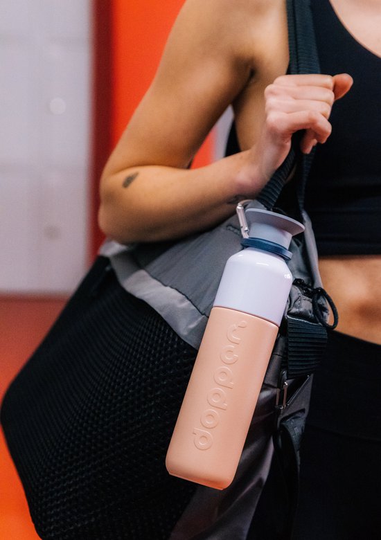 Dopper Insulated drinkfles in pebble peach, gedragen aan een sporttas.