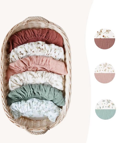 Witte, roze, roestbruine en mintgroene wiegdekjes met bloemenprint, in een mand.