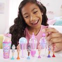 Een meisje kijkt naar een rij miniatuur Barbiepoppen en verrassingsbekers.