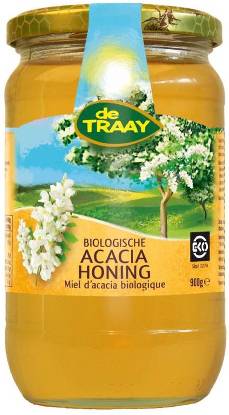 Glazen pot biologische acaciahoning van De Traay met een label met een landschap, bloeiende boom en witte bloemen. 900g.
