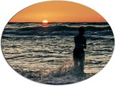 Dibond Ovaal - Silhouet van Vrouw in de Wilde Zee tijdens Zonsopkomst - 80x60 cm Foto op Ovaal (Met Ophangsysteem)