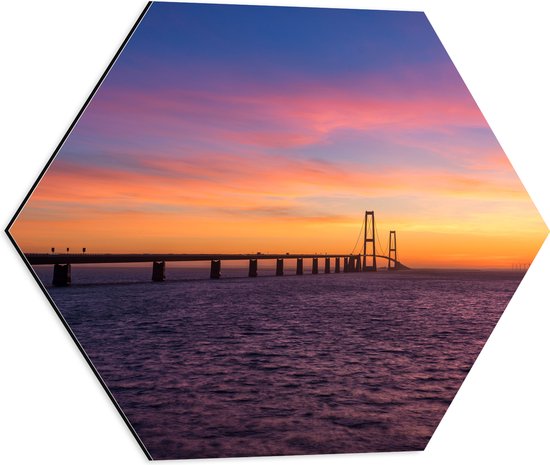 Dibond Hexagon - Uitzicht op De Grote Beltbrug tijdens Zonsondergang in Korsør, Denemarken - 50x43.5 cm Foto op Hexagon (Met Ophangsysteem)