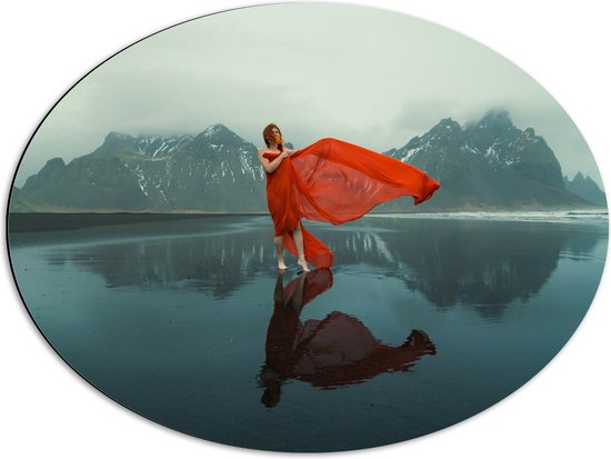 Dibond Ovaal - Vrouw in Sierlijk Rode Jurk Dansend op het IJs in Berglandschap - 68x51 cm Foto op Ovaal (Met Ophangsysteem)