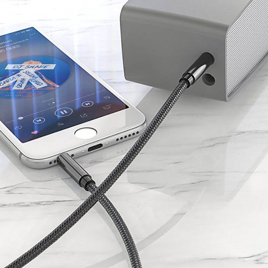 Câble audio noir à texture tressée, connecté à un smartphone et un haut-parleur gris.
