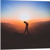 WallClassics - PVC Schuimplaat- Silhouet Persoon tussen de Bergen bij Zonsondergang - 80x80 cm Foto op PVC Schuimplaat