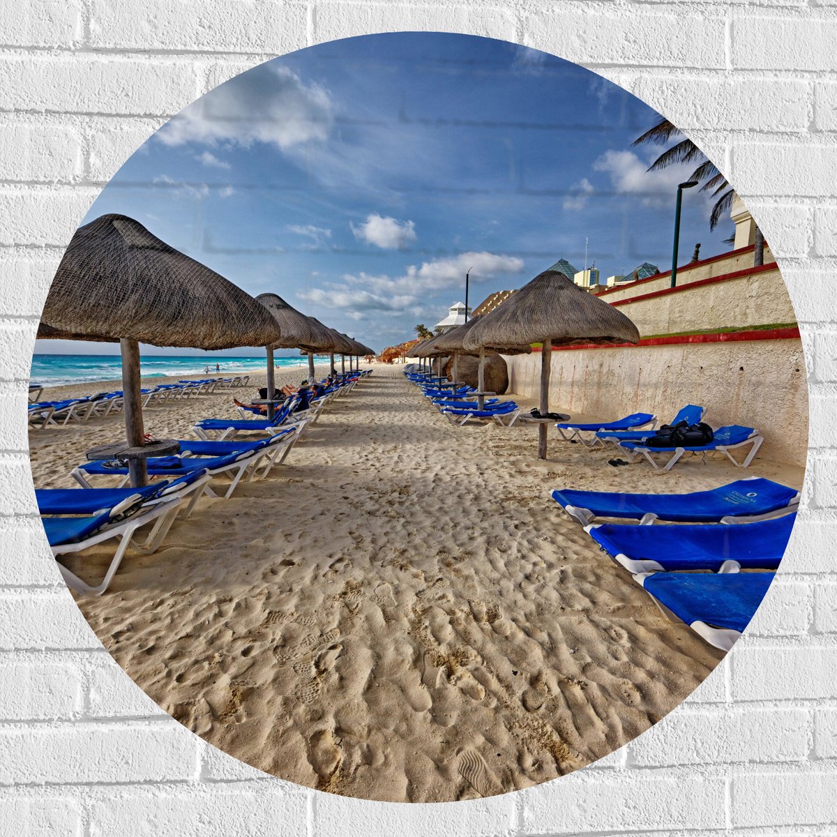 Muursticker Cirkel - Blauwe Ligbedden op Strand met Rieten Parasols - 90x90 cm Foto op Muu