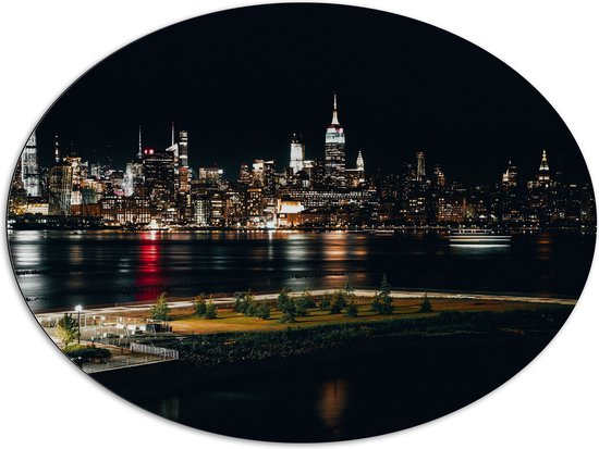 Dibond Ovaal - Skyline in New York in de Nacht - 108x81 cm Foto op Ovaal (Met Ophangsysteem)