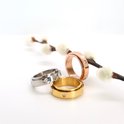 Drie draaibare ringen in het goud, rosé goud en zilver met elk vier steentjes.