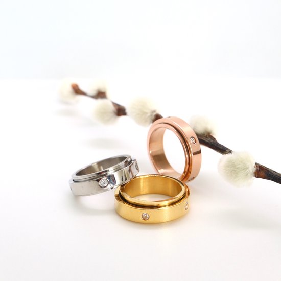 Drie draaibare ringen in het goud, rosé goud en zilver met elk vier steentjes.