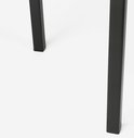 Bas d'un support de plante noir en métal avec des pieds carrés.