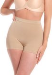 Vrouw in beige corrigerende shorts en een bijpassende beha. De shorts hebben een hoge taille en pijpen tot halverwege het bovenbeen.