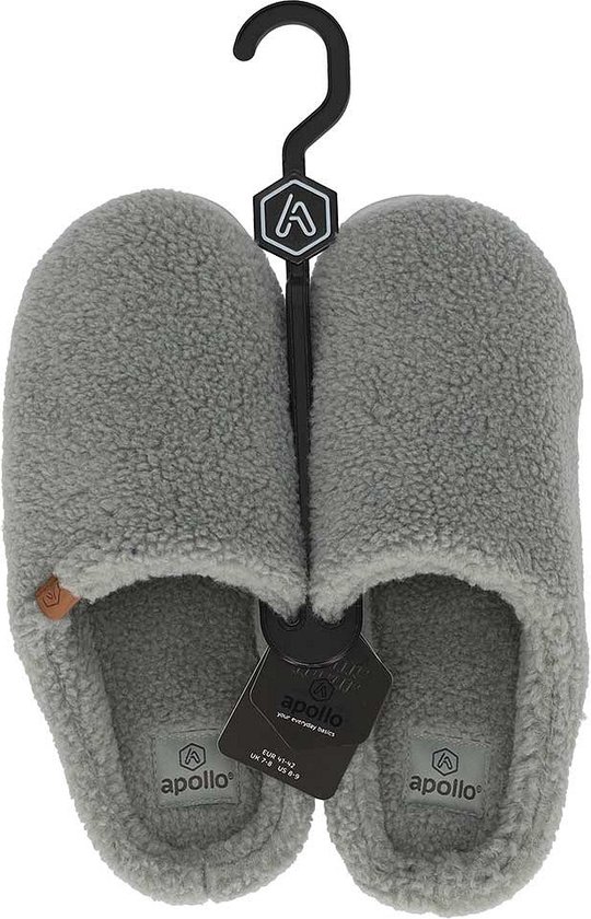 Een paar grijze teddy pantoffels hangend aan een zwarte hanger. Labels met 'apollo' zijn zichtbaar.