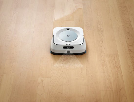 Witte robotdweilrobot op houten vloer, spuit water voor reiniging.