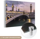 MuchoWow® Glasschilderij 180x120 cm - Schilderij acrylglas - Een verlichte brug in het Franse Parijs - Foto op glas - Schilderijen