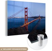 MuchoWow® Glasschilderij 120x80 cm - Schilderij acrylglas - Golden Gate Bridge verlicht in de avond - Foto op glas - Schilderijen