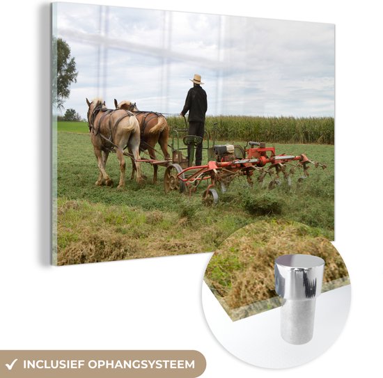 MuchoWow® Glasschilderij 180x120 cm - Schilderij acrylglas - Een man gebruikt zijn paarden om zijn veld te ploegen - Foto op glas - Schilderijen