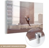 MuchoWow® Glasschilderij 120x80 cm - Schilderij acrylglas - Dansende vrouw op het dak van een gebouw - Foto op glas - Schilderijen