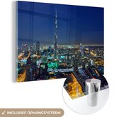 MuchoWow® Glasschilderij 90x60 cm - Schilderij acrylglas - Dubai en de Burj Khalifa verlicht in de avond - Foto op glas - Schilderijen