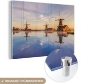 MuchoWow® Glasschilderij 120x80 cm - Schilderij acrylglas - Zonsondergang boven windmolens aan het water - Foto op glas - Schilderijen