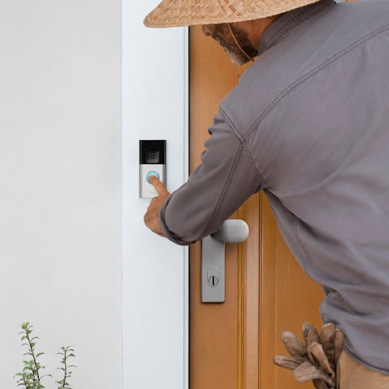 Man met strooien hoed drukt op een zilverkleurige Ring deurbel.