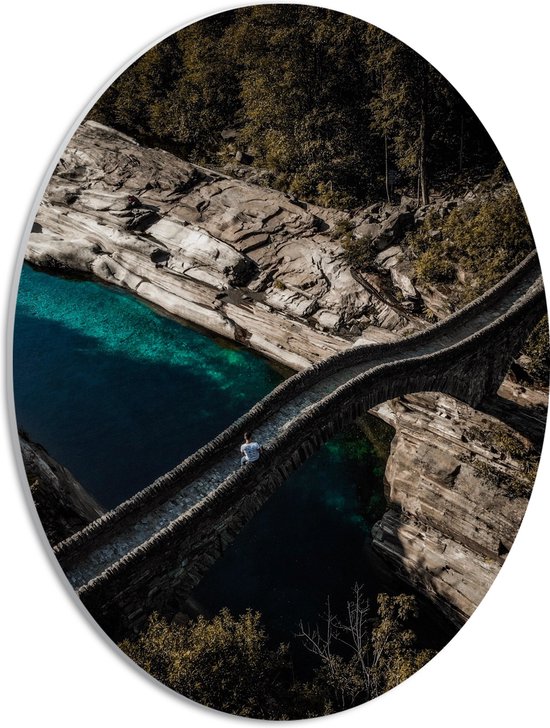 WallClassics - PVC Schuimplaat Ovaal - Smalle Brug over Blauwe Rivier in Natuur Landschap - 30x40 cm Foto op Ovaal (Met Ophangsysteem)