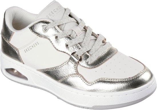 Vooraanzicht van een witte sneaker met champagnekleurige leren accenten, veters en een witte zool met luchtdemping.